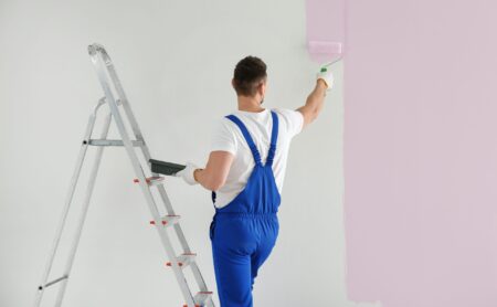 Man painting walls in empty room